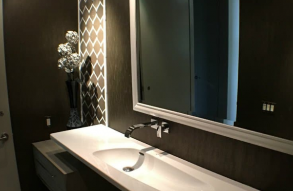 Kamar mandi dengan kaca cermin yang menciptakan ilusi ruang yang luas